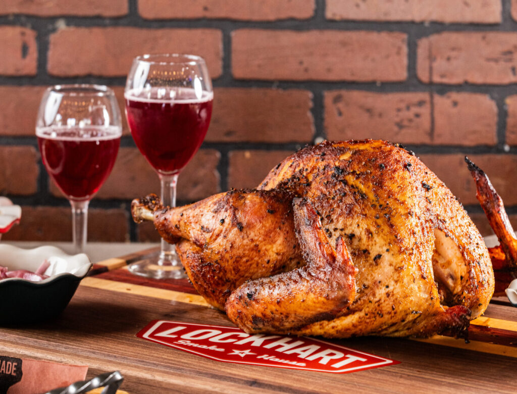 2 wine glasses with red wine, bbq chicken